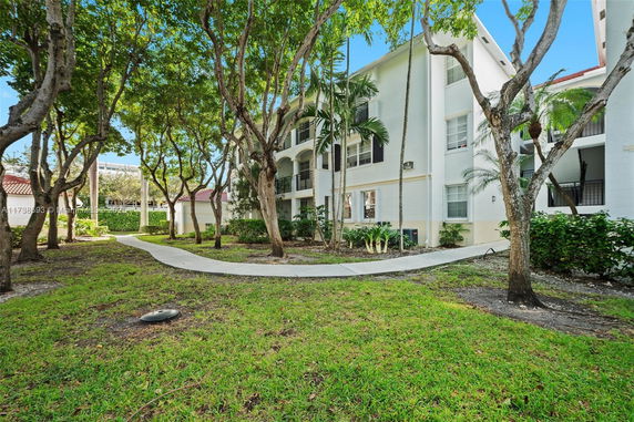 Front view of a multi-story building with surrounding greenery.