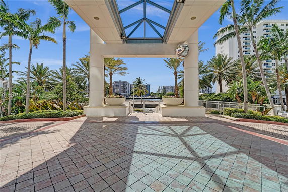 Outdoor area with palm trees and distant view of buildings.