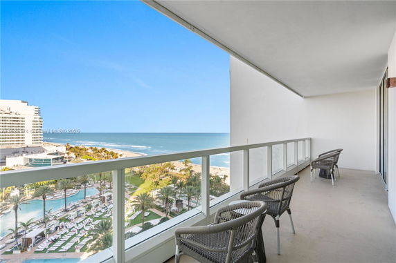View from a balcony overlooking the ocean and beach area.