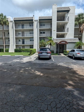 Front view of a multi-story building with parking spaces.