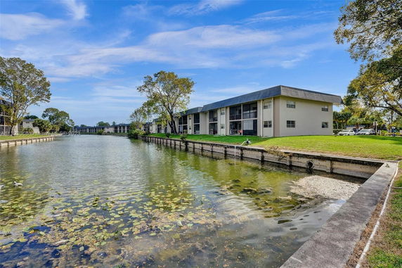 View of residential buildings near a waterway with grassy surroundings