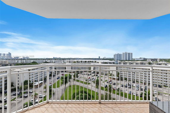 Panoramic view from a high-rise building balcony overlooking surrounding residential buildings.