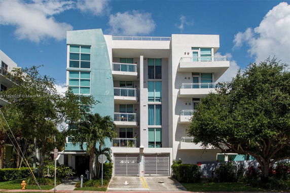 Front view of a modern multi-story apartment building with balconies.