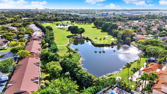 Panoramic view of a golf course with surrounding residential area.