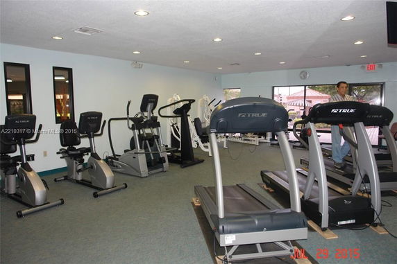 Interior view of a gym area with exercise equipment including treadmills and stationary bikes.