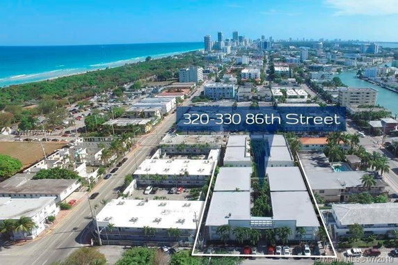 Aerial view of a coastal urban area with numerous buildings and roads near the beach.