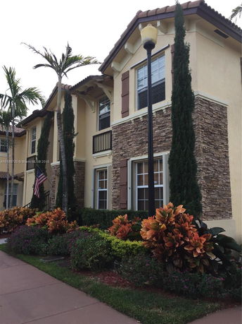 Front view of a two-story house with stone accents and shutters.