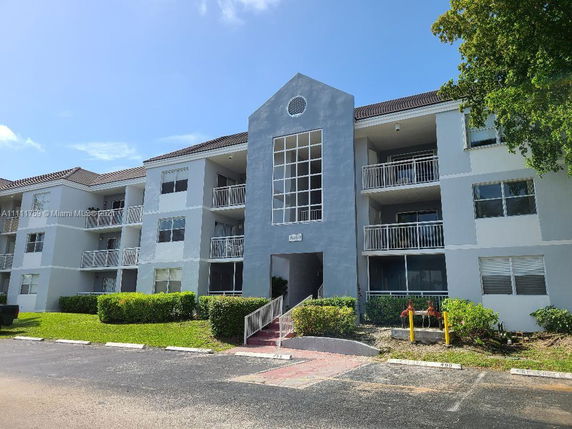 Front view of a three-story apartment building with balconies.