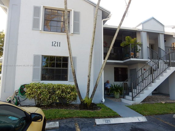 Front view of a two-story residential building with exterior stairs.