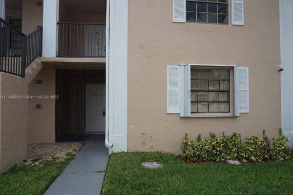 Front view of a two-story building with balconies and windows.