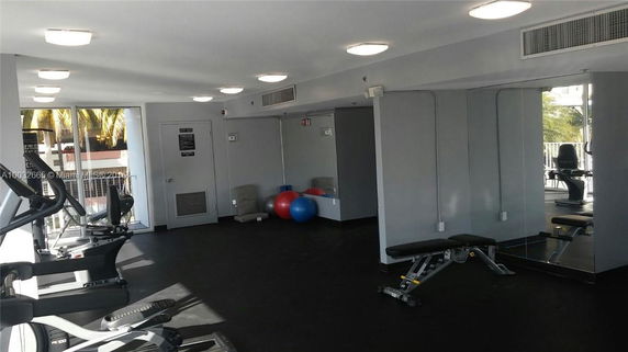 Indoor gym area with exercise equipment and mirrors.