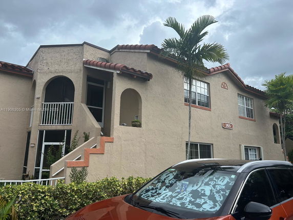 Front view of a multi-story building with stairs and arches.