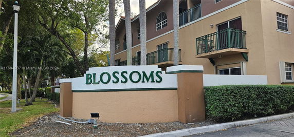Front view of a residential building with balconies, labeled 'Blossoms'.