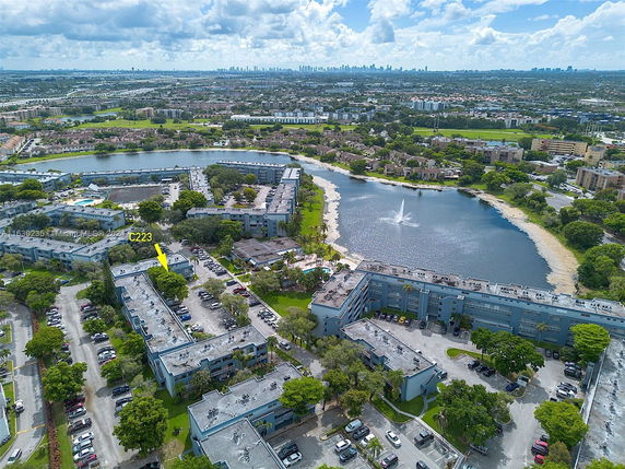 Panoramic view of residential buildings and a lake with a fountain.