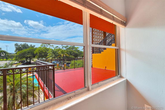 View through a window overlooking a terrace and trees outside.
