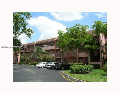 Front view of a multi-story residential building with a parking area.
