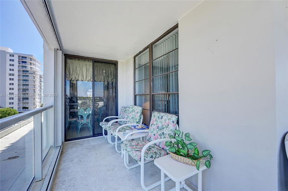 Balcony area with outdoor seating and view of surrounding buildings.