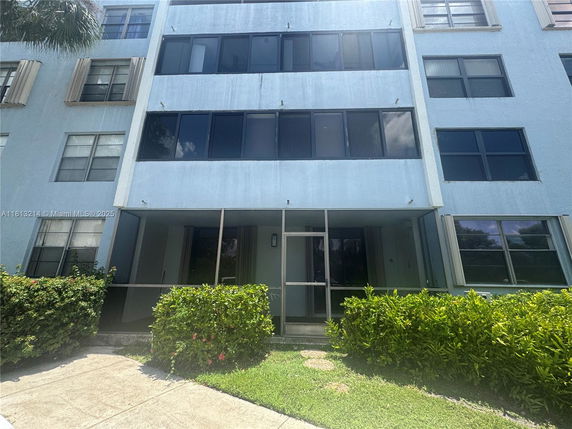 Front view of a multi-story residential building with blue exterior and multiple windows.