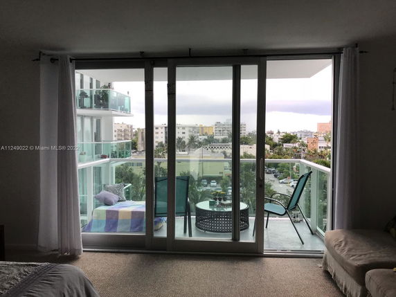 View of surrounding areas from a high-rise balcony with chairs and table.
