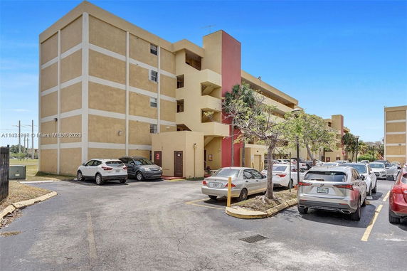 Outdoor parking area beside a multi-story apartment building.