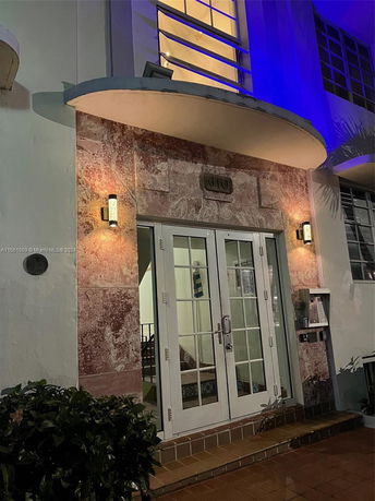 Front view of a building entrance with glass double doors and decorative lighting.