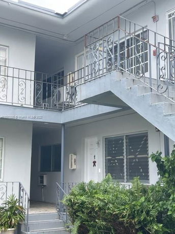 Front view of a two-story building with exterior staircases and balconies.