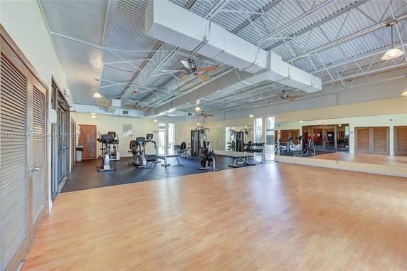 Indoor gym area with exercise equipment and wooden flooring.