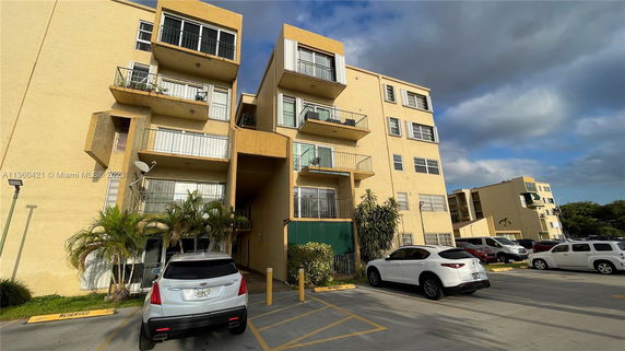 Front view of a multi-story apartment building with balconies.