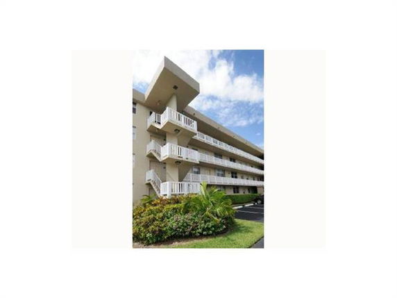 Front view of a multi-story apartment building with balconies.