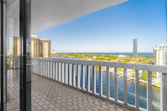 Wide angle view from a balcony overlooking a cityscape and body of water.