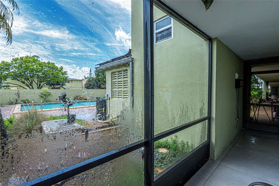 View from a building showcasing a pool area and greenery.