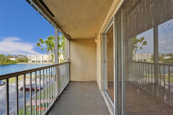 Balcony with railing overlooking a body of water and surrounding buildings.