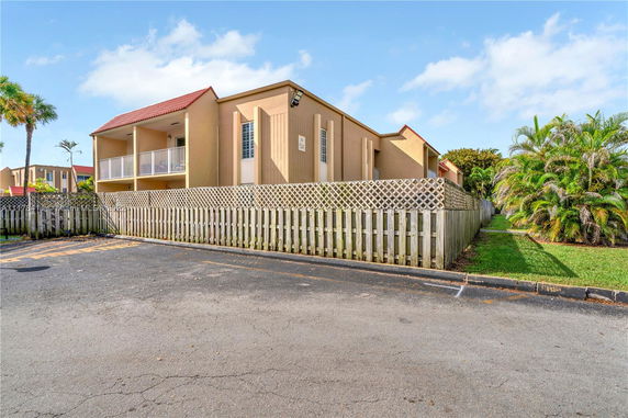 Front view of a building with a fenced yard and balconies.