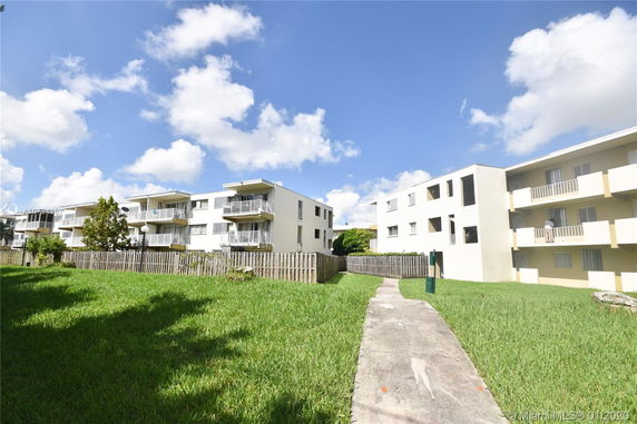Front view of a multi-story apartment building with balconies.