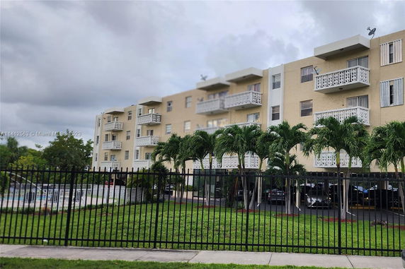 Front view of a multi-story apartment building with balconies and decorative railings.