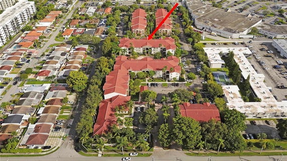 Aerial view of a residential area with multiple buildings and a parking lot.