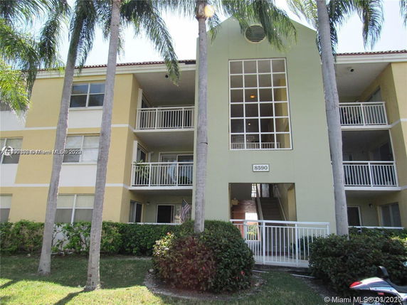 Front view of a multi-story apartment building with balconies.