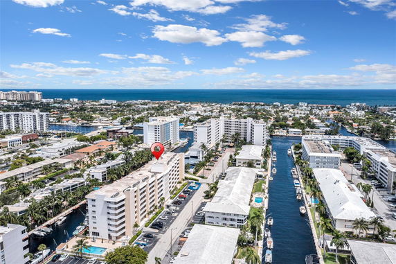 Aerial panoramic view of coastal residential buildings with waterways and the ocean in the background.
