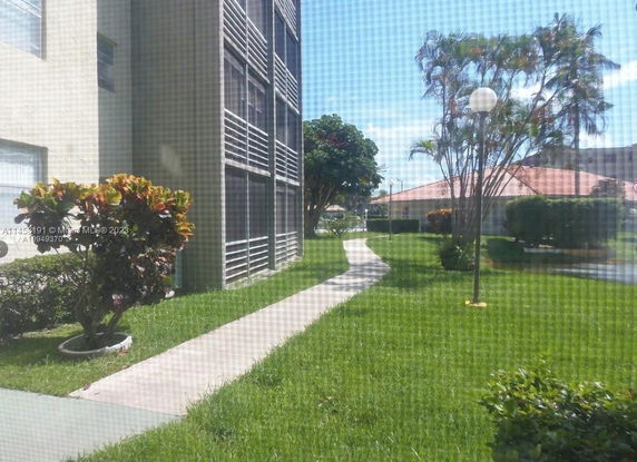 View of building exteriors and surrounding garden area with walkway.