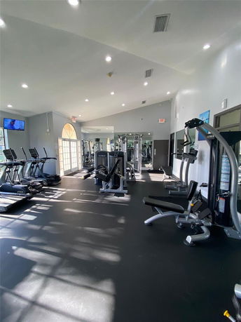 Indoor gym area with exercise equipment and mirrored walls.