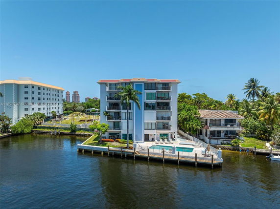 Front view of a multi-story waterfront building with balconies.