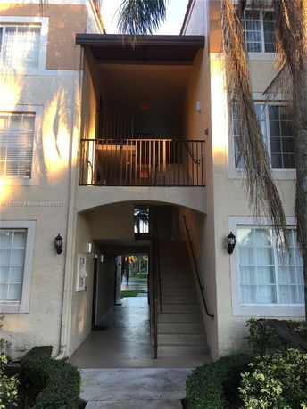 Front view of a multi-story building with exterior stairs and balconies.