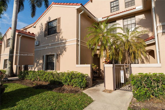 Front view of a two-story house with a gated entrance and red-tiled roof.