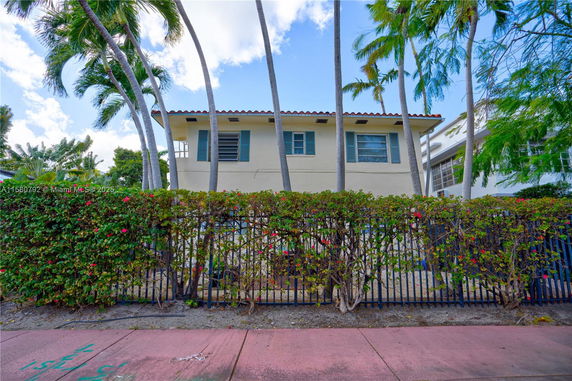 Front view of a two-story house with blue shutters and a tile roof.
