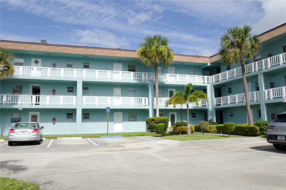 Front view of a multi-story apartment building with balconies.
