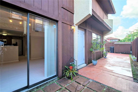 Front view of a two-story house with wooden exterior and sliding glass door.