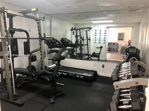 Indoor gym with exercise equipment and dumbbells.