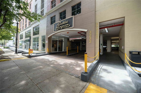 Front view of a multi-story building with a covered driveway and entrance.