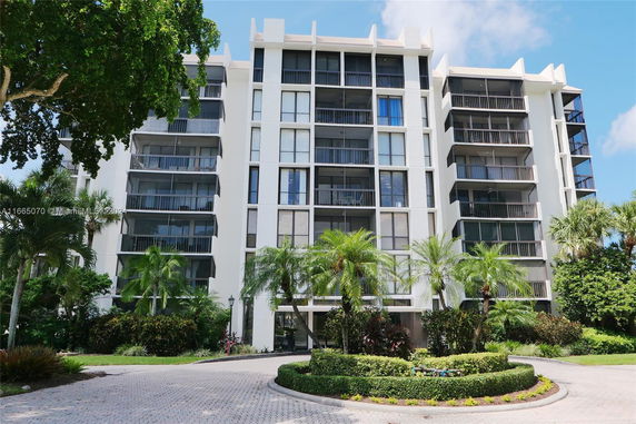 Front view of a modern multi-story apartment building with balconies.