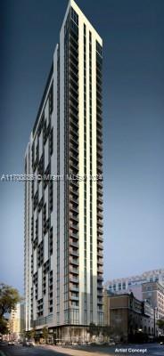 Front view of a tall, modern high-rise building with numerous balconies.